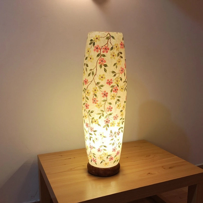 Floral-patterned lamp on a wooden table with a soft glow.